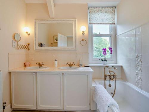 a bathroom with two sinks and a tub and a mirror at 3 Bed in Brecon oc-bn134 in Brecon