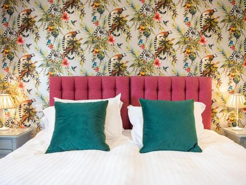 a bed with a red headboard and green pillows at 3 Bed in Bideford oc-89865 in Westward Ho