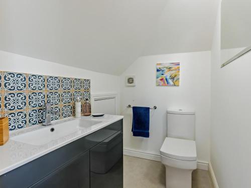 a white bathroom with a toilet and a sink at 1 Bed in Bideford oc-55340 in Instow