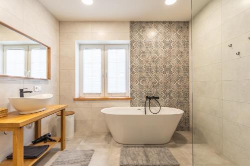 a bathroom with a tub and a sink at Villa Asta in Rusnė
