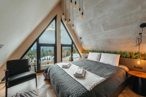 ein Schlafzimmer mit einem großen Bett und einem Stuhl in der Unterkunft Sunset A Frames in Bălceşti
