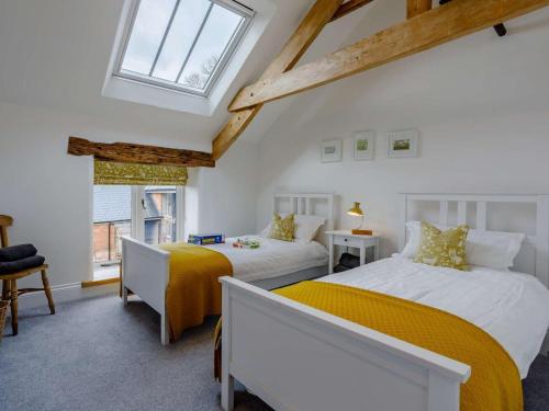 a bedroom with two beds and a window at 4 Bed in Honiton oc-45563 in Payhembury