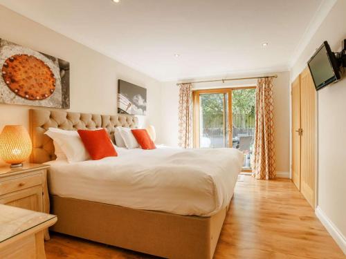 a bedroom with a large bed with orange pillows at 3 Bed in Bideford oc-89866 in Westward Ho