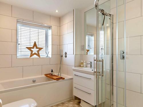 a bathroom with a shower and a toilet and a sink at 3 Bed in Bideford oc-89018 in Westward Ho