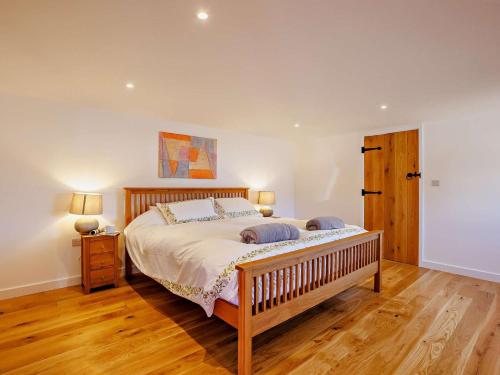 a bedroom with a large bed and a wooden floor at 2 Bed in Kings Nympton oc-87985 in Kings Nympton