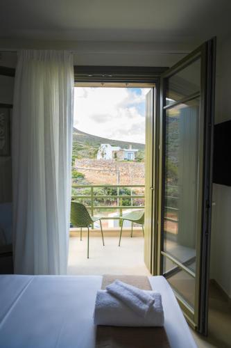 a bedroom with a bed and a view of a balcony at Villa Artemis 5 - Etheras Properties in Kythira