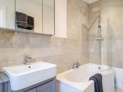 a bathroom with a white sink and a bath tub at 2 Bed in Crediton oc-78468 in Cheriton Fitzpaine