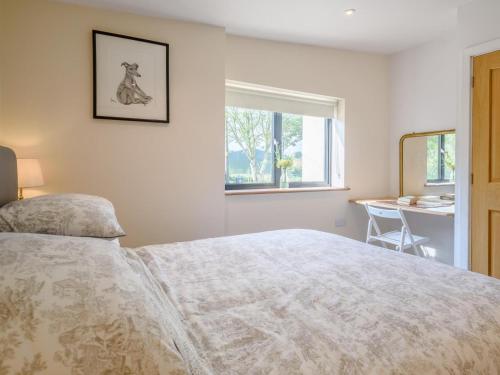 a bedroom with a bed and a desk and a window at 2 Bed in Crediton oc-78468 in Cheriton Fitzpaine