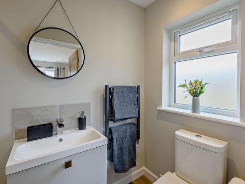 a bathroom with a sink and a mirror and a toilet at 1 Bed in Barnstaple oc-91387 in Marwood