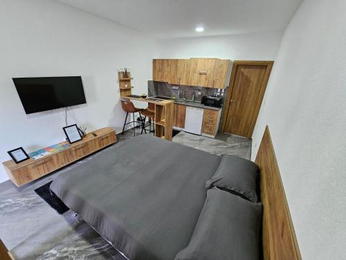 ein Schlafzimmer mit Bett und Schreibtisch sowie eine Küche in der Unterkunft MALM Travnik in Travnik