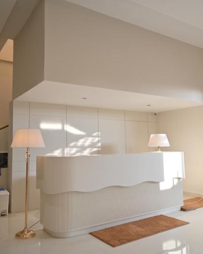 a white kitchen with a table and a lamp at Hotel Phantom in Gangānagar