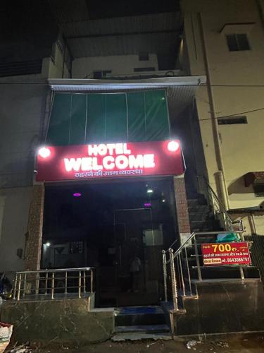 a neon sign for a hotel with a sign for a room at HOTEL Welcome in Jāmb