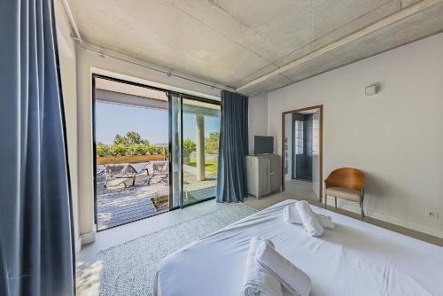a bedroom with a bed and a large window at Villa Ciel, vue mer in Pyla-sur-Mer