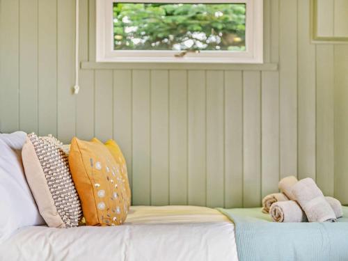 a couch with pillows on it in a room with a window at 1 Bed in Paignton oc-93063 in Marldon