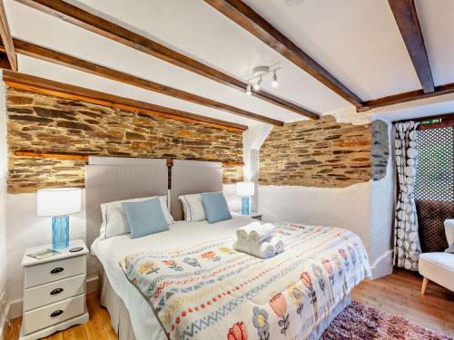 a bedroom with a bed and a stone wall at 1 Bed in Yelverton oc-93333 in Yelverton