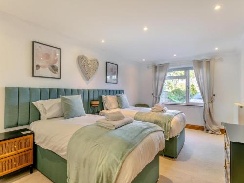 a bedroom with two beds and a window at 4 Bed in Bideford oc-91814 in Northam