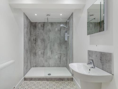 a white bathroom with a sink and a shower at 4 Bed in Bideford oc-91814 in Northam