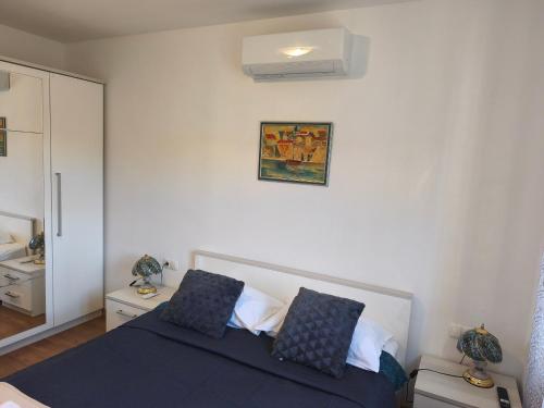 a bedroom with a blue bed with two pillows at Villa Leen Dubrovnik in Ðurinići
