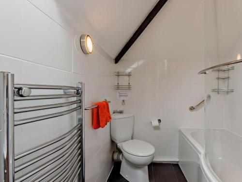a white bathroom with a toilet and a bath tub at 2 Bed in Bideford oc-housm in Clovelly