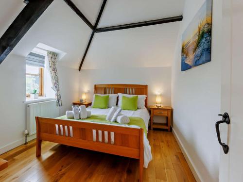 a bedroom with a large bed with green pillows at 2 Bed in Bideford oc-housm in Clovelly