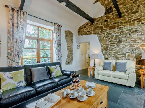 a living room with a black leather couch and a table at 4 Bed in Bideford oc-owlbr in Clovelly