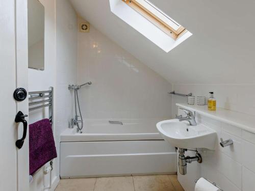 a white bathroom with a sink and a bath tub at 4 Bed in Bideford oc-owlbr in Clovelly