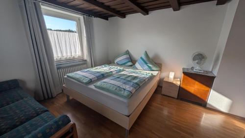 a bedroom with a bed and a window at Ferienwohnung Hinterberg in Fürstenstein
