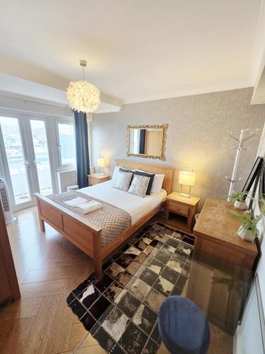 a bedroom with a bed and a table and a mirror at Luxury Beachfront Apartment Brighton Centre in Brighton & Hove