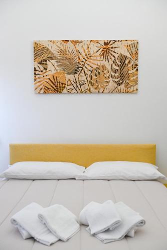 a white bed with two white towels on it at GIKLA MAISON in Catania