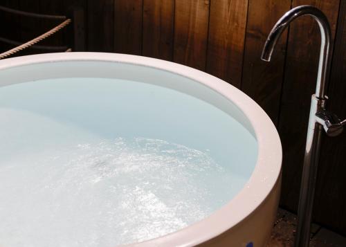 a bath tub filled with water in a bathroom at Beach Front Seretis in Shimoda