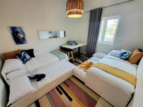 a living room with a couch and a cat sitting on it at Family Floatie Flat with Pool & Workspace in As Sīfah