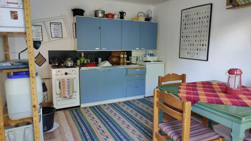 a kitchen with blue cabinets and a table and a table and a tableablish at Naawa Nature Camp in Korppoo