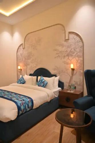 a hotel room with a bed and a chair at Hotel Phantom in Gangānagar