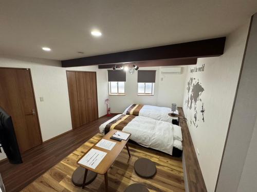a bedroom with a bed and a table in it at Swiss 1960 in Sumoto