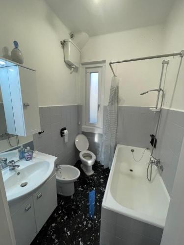 a bathroom with a white sink and a toilet at Casa Nora in Trieste