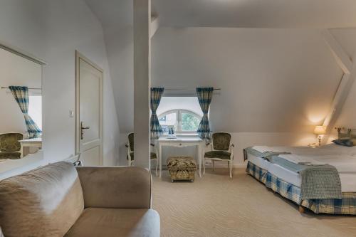 a bedroom with a bed and a couch and a table at Pałac Brunów - Wellness & SPA in Lwówek Śląski