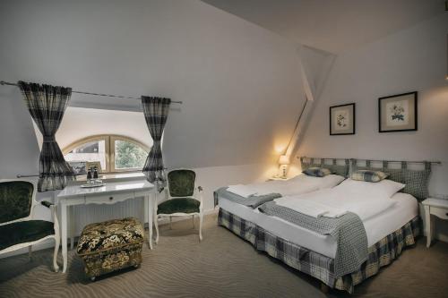 a bedroom with a bed and a desk and a window at Pałac Brunów - Wellness & SPA in Lwówek Śląski