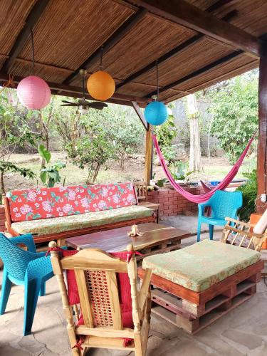 a patio with a couch and chairs and a hammock at Yellow Submarine Hostal in Poneloya