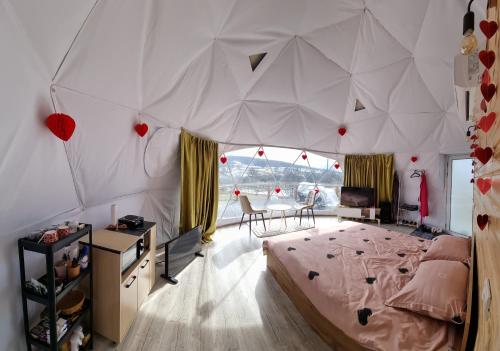 a bedroom with a large bed in a tent at GlampingDenis Igloo in Mihăeşti