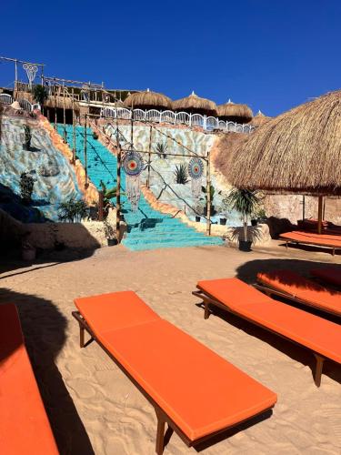 a beach with two orange benches and a water slide at Grand Halomy Megan in Sharm El Sheikh