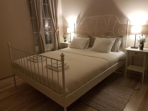 a bedroom with a white bed with white pillows at Kambarys prie vynuogyno in Pikeliškės
