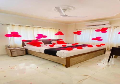 a bedroom with a large bed with red flowers on it at Hotel RP Residency in Nakraunda