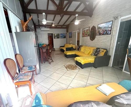 a large living room with yellow couches and chairs at residence caramboles in Fort-de-France