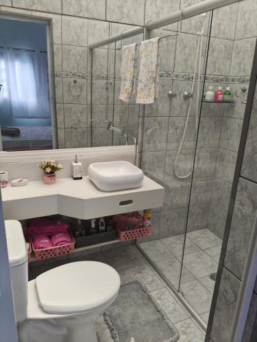 a bathroom with a shower and a toilet and a sink at Casa de praia in Peruíbe