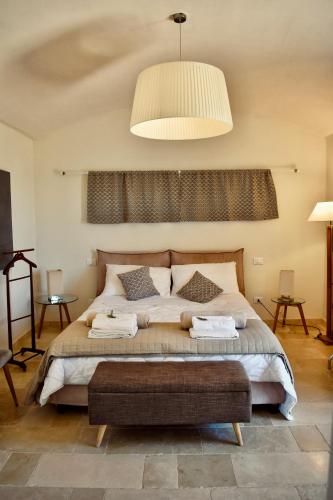 a bedroom with a large bed and a pendant light at Trullo Theodoro Puglia in Ceglie Messapica