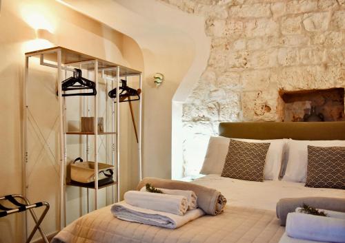 a bedroom with a bed with towels on it at Trullo Theodoro Puglia in Ceglie Messapica