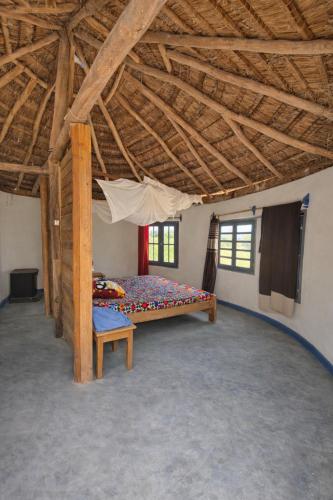 a bedroom with a bed in a room with wooden ceilings at Espace baleine Anakao in Anakao