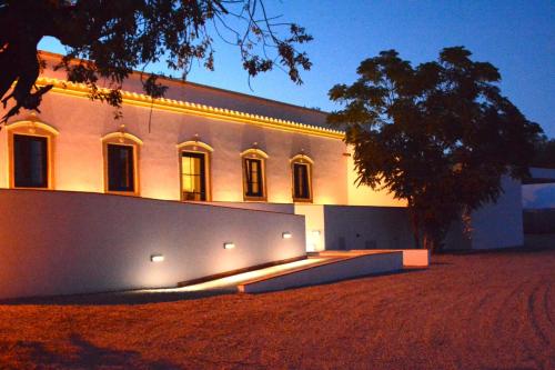 a building with lights on the side of it at night at Quinta do Coelhoazul in Quelfes