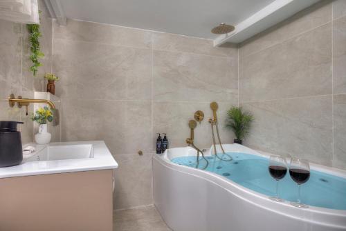 a bathroom with a tub with two glasses of wine at Mountain Top Views -205- נופי פסגות in Safed