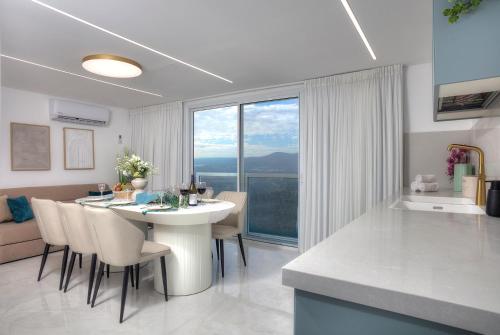 a kitchen and living room with a table and chairs at Mountain Top Views -205- נופי פסגות in Safed